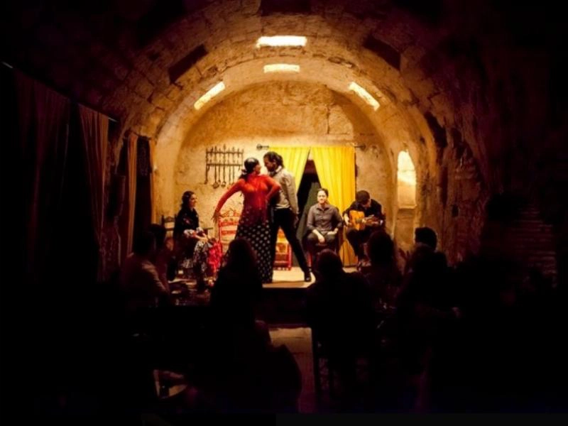 Couple dancing flamenco in a semi dark arched room