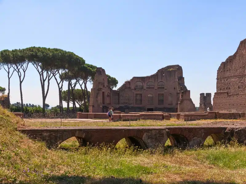 Some tourists walk near the remnants of the Palatine Stadium, in the area of the Palatine Hill, Roman Forum.