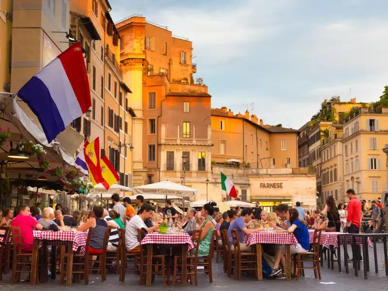 People having aperitif which in Italy traditionally includes free all you can eat buffet of pizzas and pastas on Piazza Campo De Fiori in Rome in Italy.