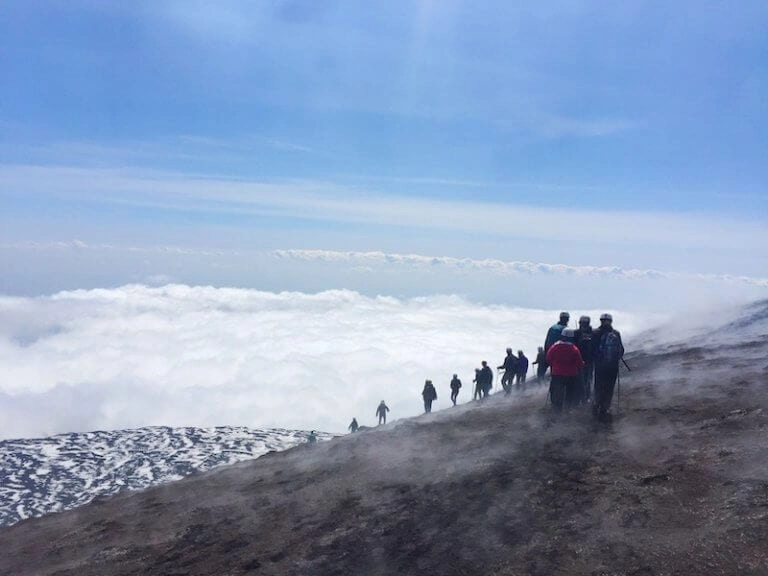 Climing Mount Etna in Sicily, above the clouds with a clear blue sky