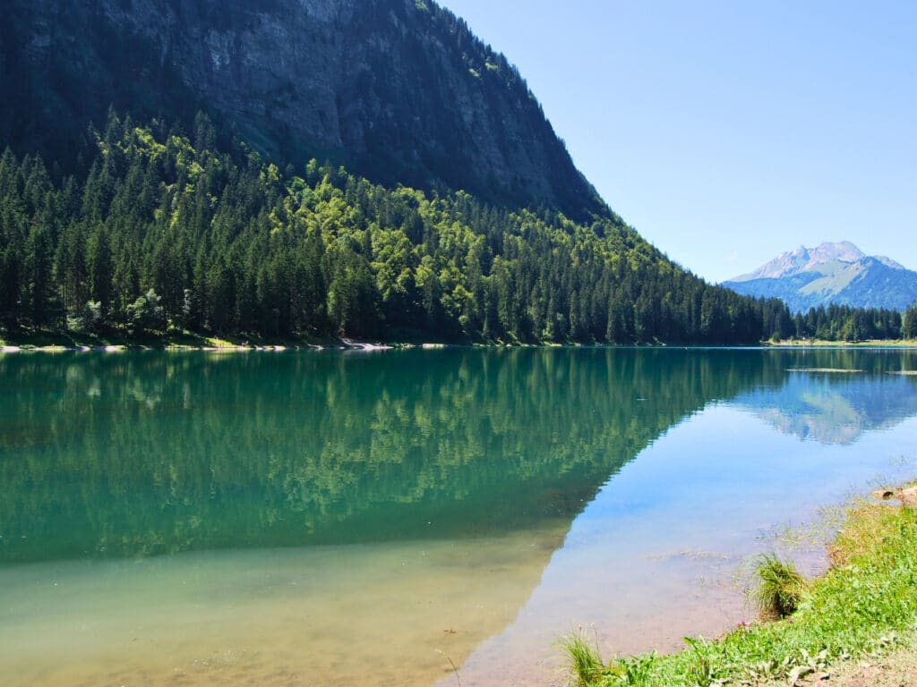 clear mirror lake of turquoise surrounded by trees