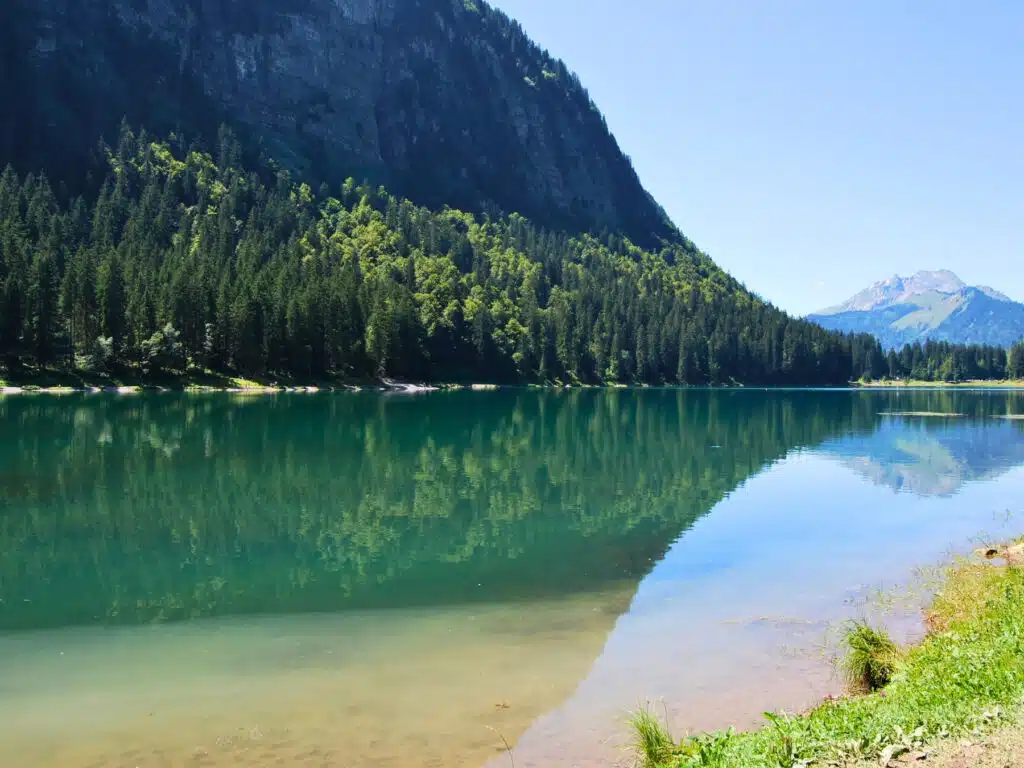 clear mirror lake of turquoise surrounded by trees