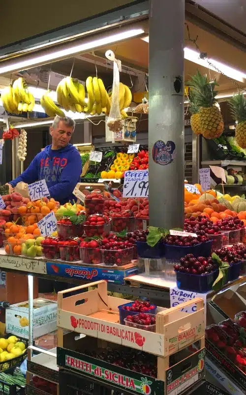 market stall full of fruit including bananas, pineapple, oranges, strawberries and cherries