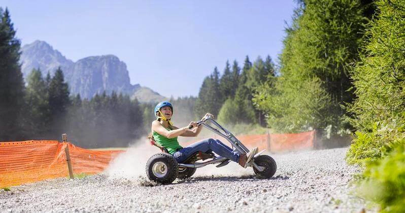 woman riding in a go cart on a gravel track