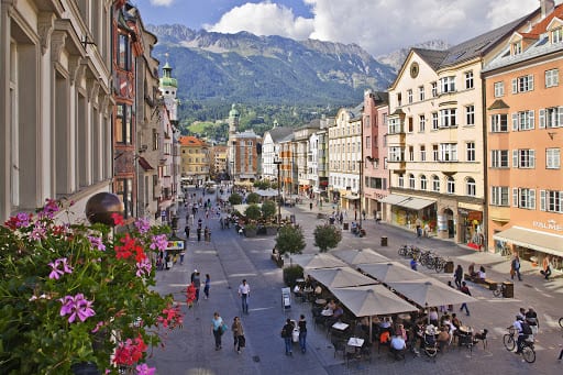 historic buildings lining a busy street with mountain views