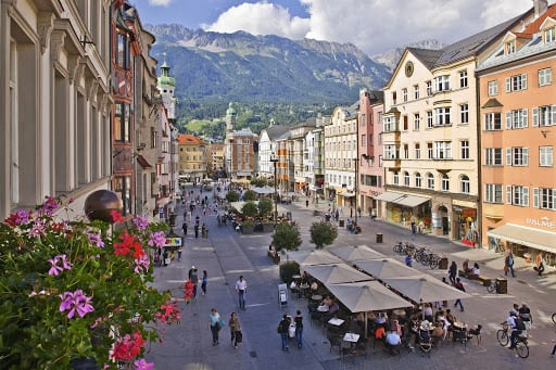 historic buildings lining a busy street with mountain views