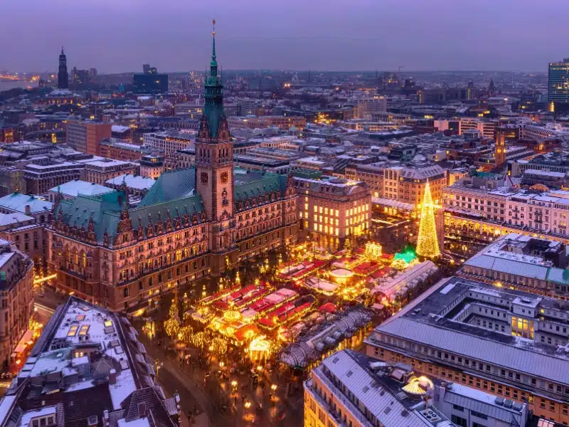 Aerial view of illuminated historic Christmas market on Rathausmarkt in downtown of Hamburg, Germany in the evening.