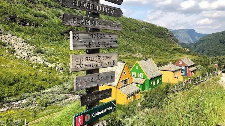 colourful houses behind a wooden signpost