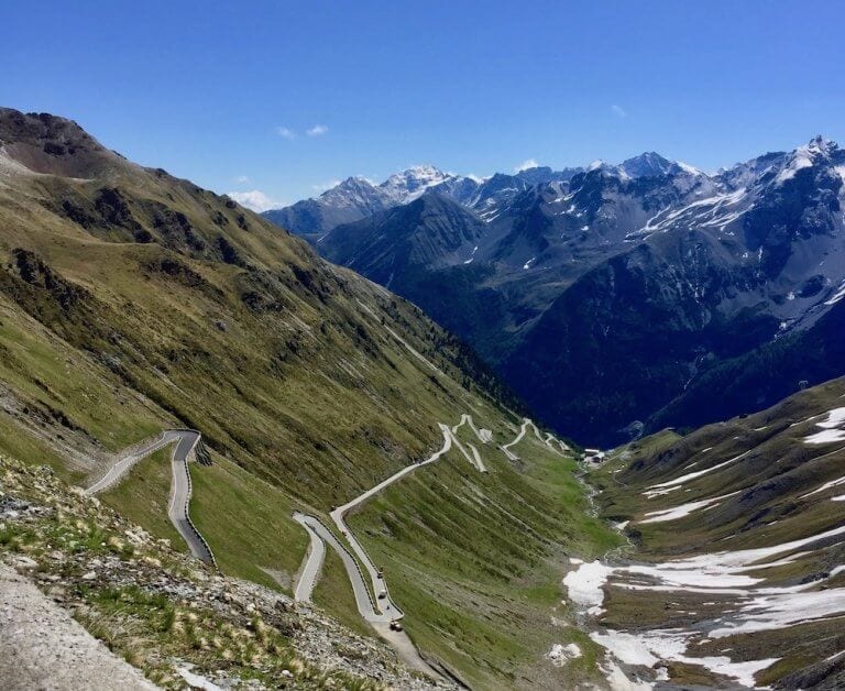 a road snaking along a mountain pass in Italy