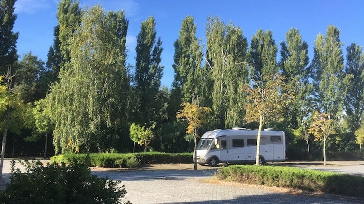 Silver A class motorhome parking in a tree lined car park in Portugal