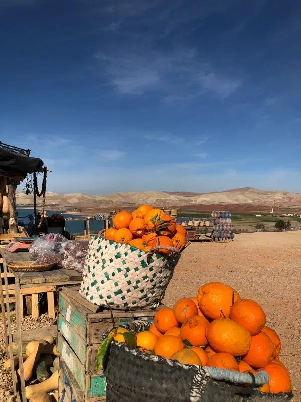 Oranges for sale in woven baskets on a roadside stall