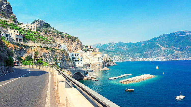 the Amalfi coast road with a small town in front and the turquoise sea to the right