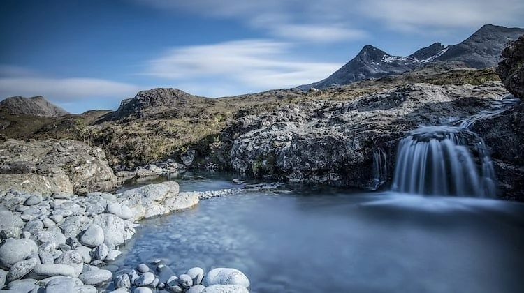 Pool with a small waterfall surrounded by rocky fells