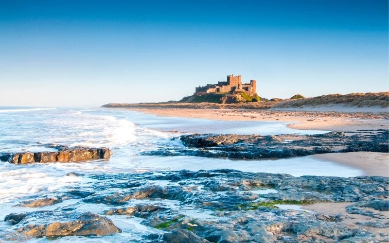 large castle standing next to a beach