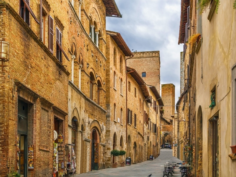 Narrow street lined with tall red brick medieval buildings