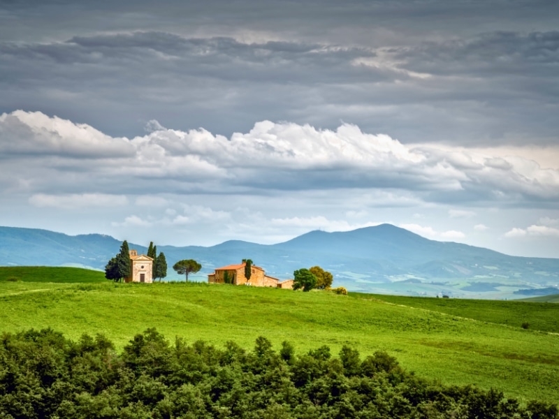 Small chapel and house on the crest of a grassy hill