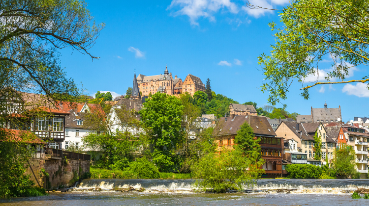 Tradtional German altstadt with colourful houses and a castle perched on a rocky crag