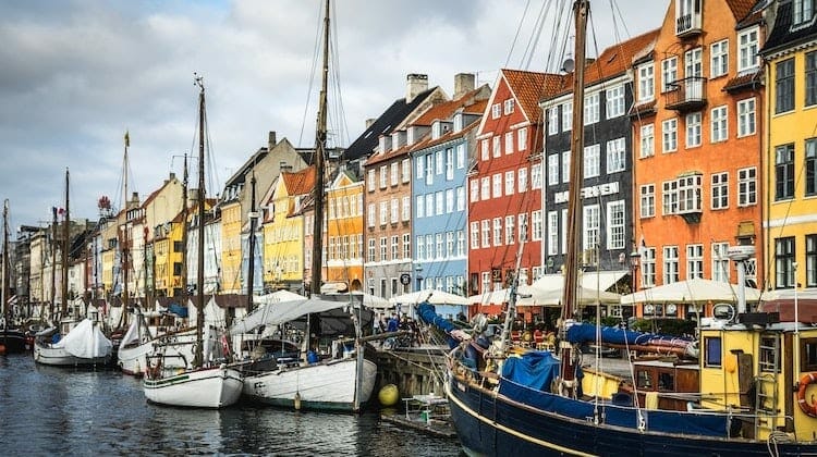 colorful houses lining a canalside street busy with boats