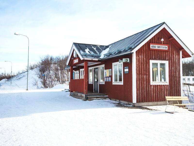 Red tin train station with snow on the platform