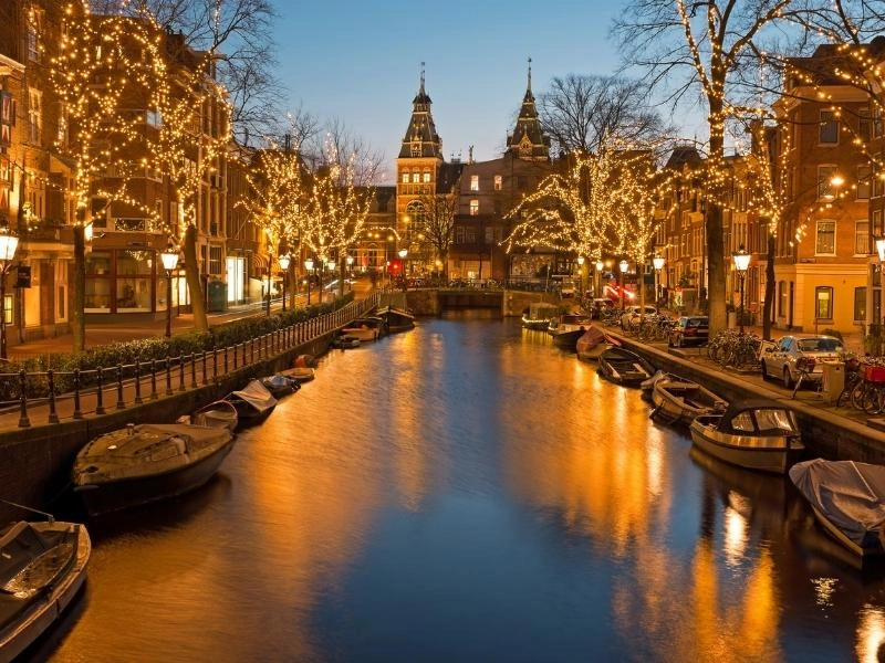 Canal in Amsterdam lined with fairy lights 