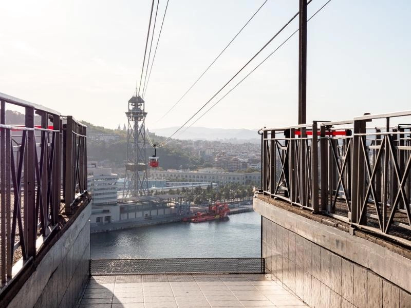 red cable car between towers over a body of water