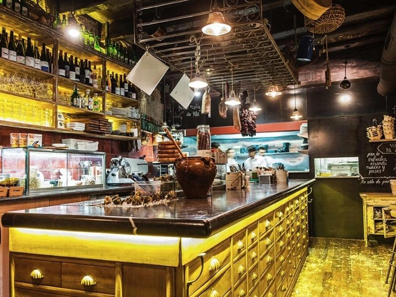 Interior of bar with wooden furnitre and bottles of wine on display