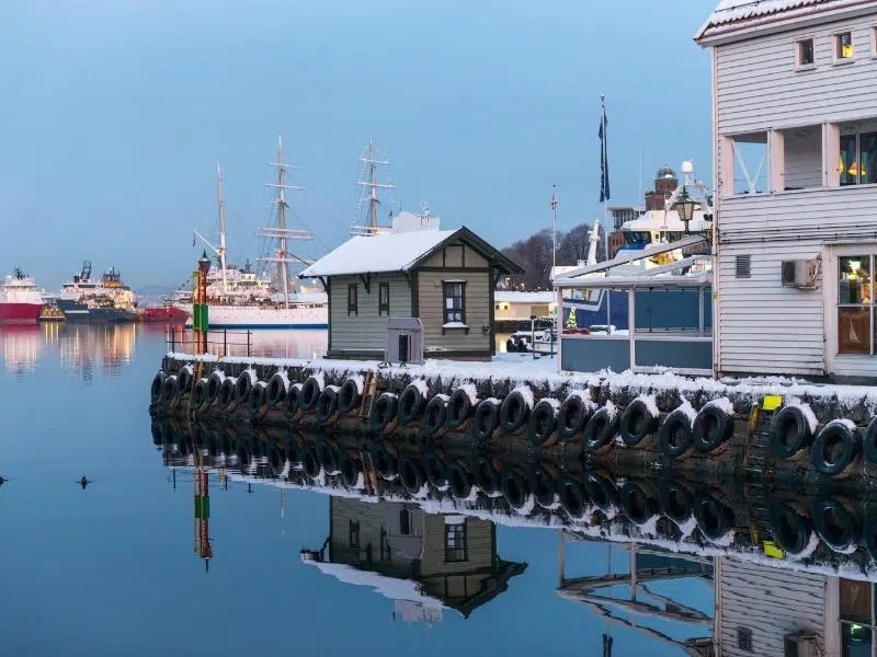 Norwegian harbour with buildings and boats covered in snow