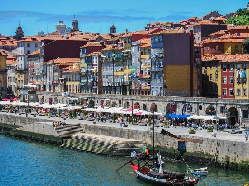 colorful buildings lining a river with people and a boat