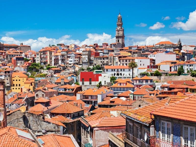 teracotta rooftops with a tall stone tower in the background