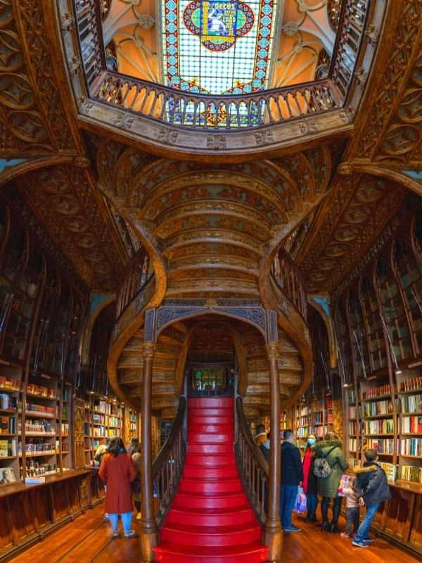 red staircase in a book shop with ornate painting on the underneath