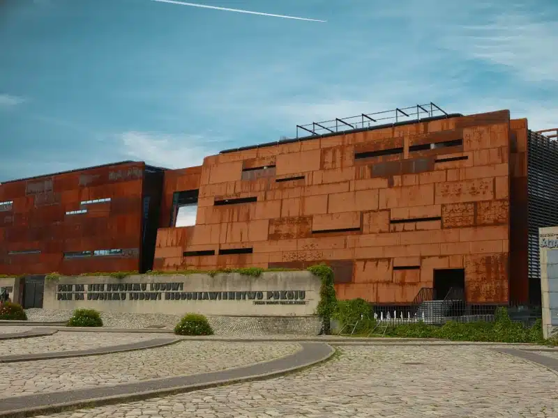 large corten steel building with cobbled driveway