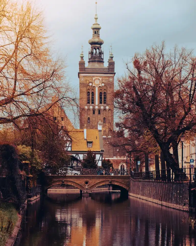 brick bridge with a half-timbered white building in the background