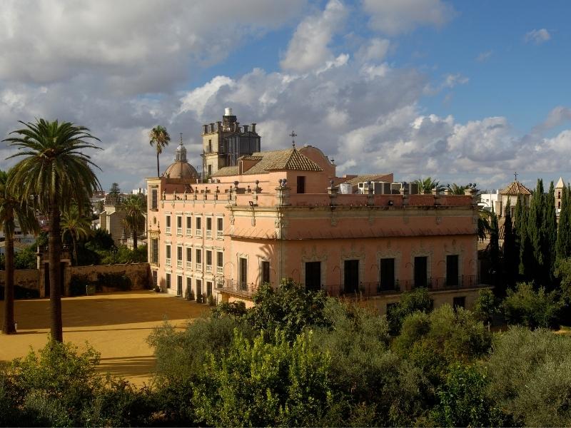 Historic building in spain with a courtyard filled with palm trees