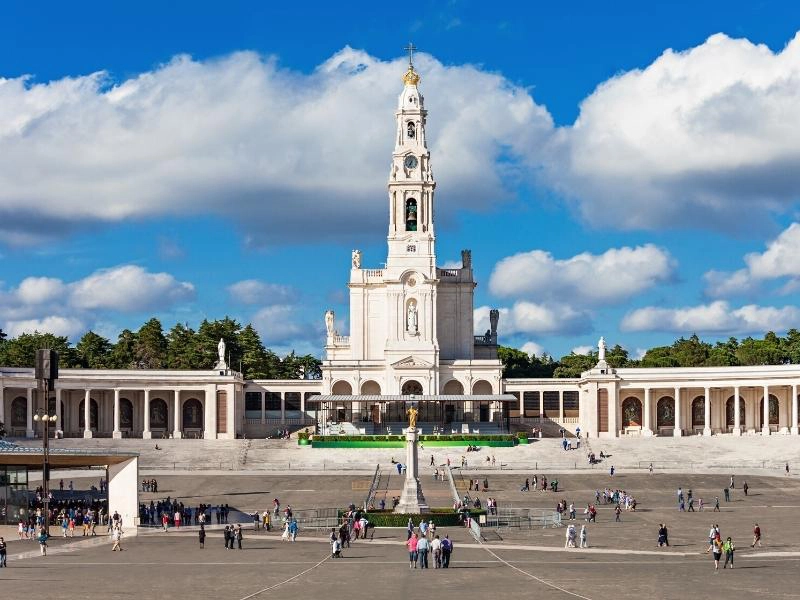 large white religious building with many people in front of it