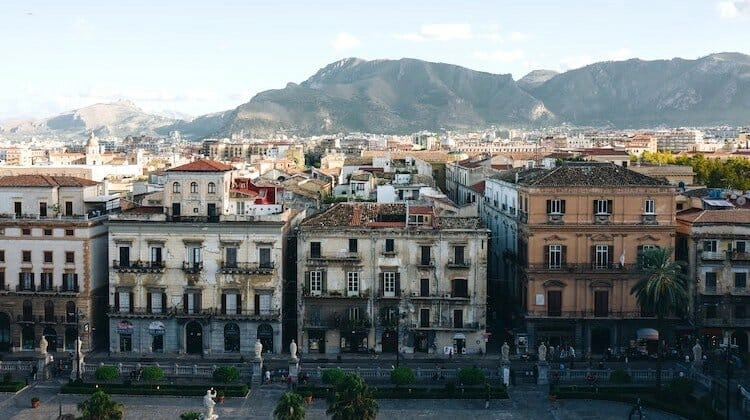 Old buildings with mountains behind in Palermo