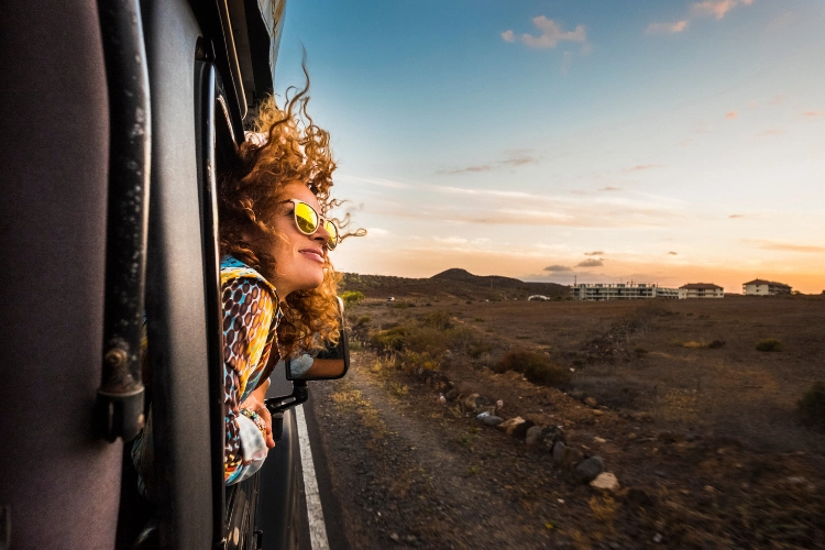 Woman hanging out of RV window wearinh mirror shades