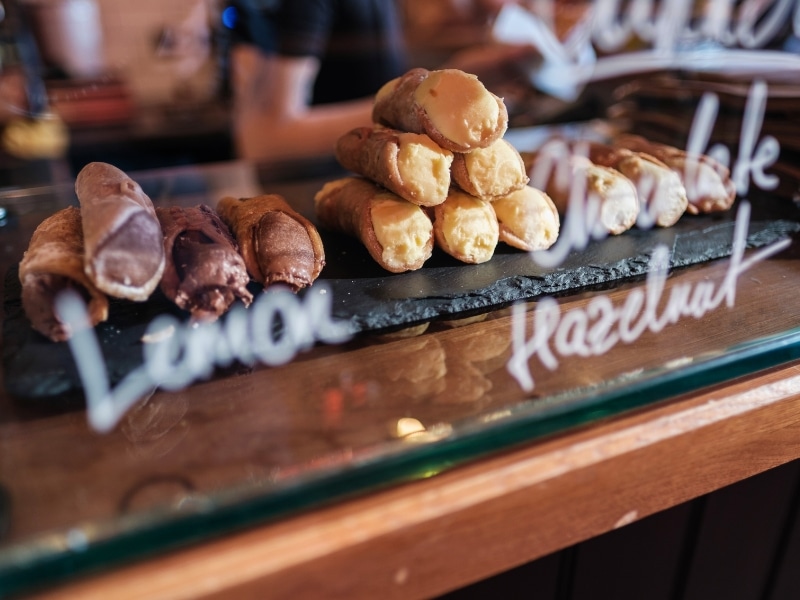 Cannoli of various flavours on display in a bakery