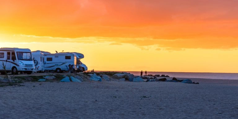 Motorhomes by the beach at sunset