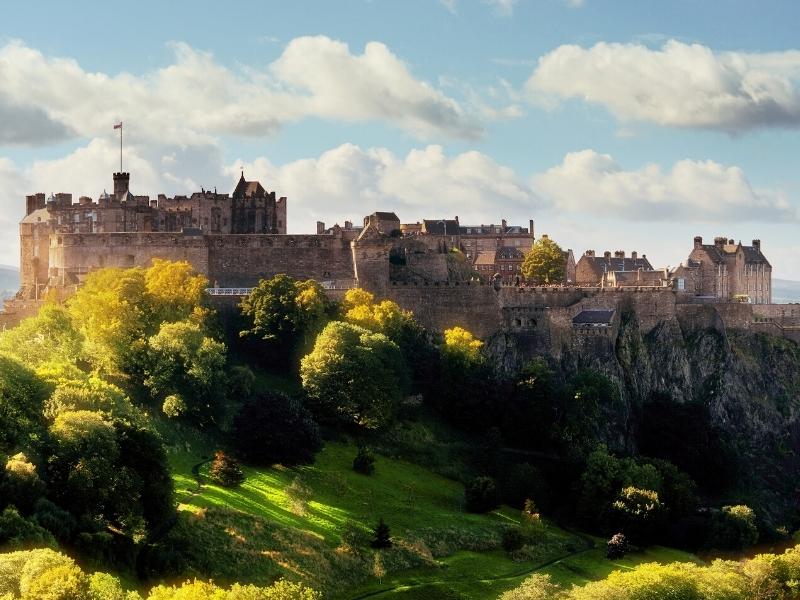 stone castle on a hill with grass and trees