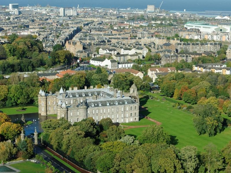 Scottish royal palace surrounded by green grass and a moat