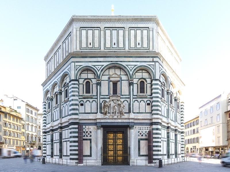 Octagonal bulding with a black and white marble facade and gold doors