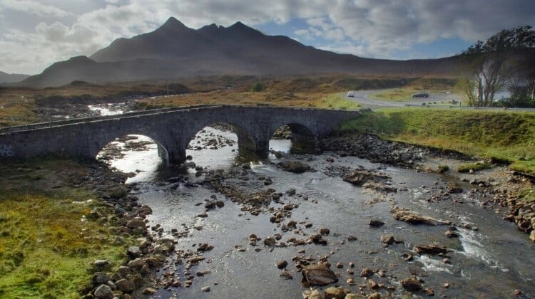 Ancient three arched bridge over a river on Skye