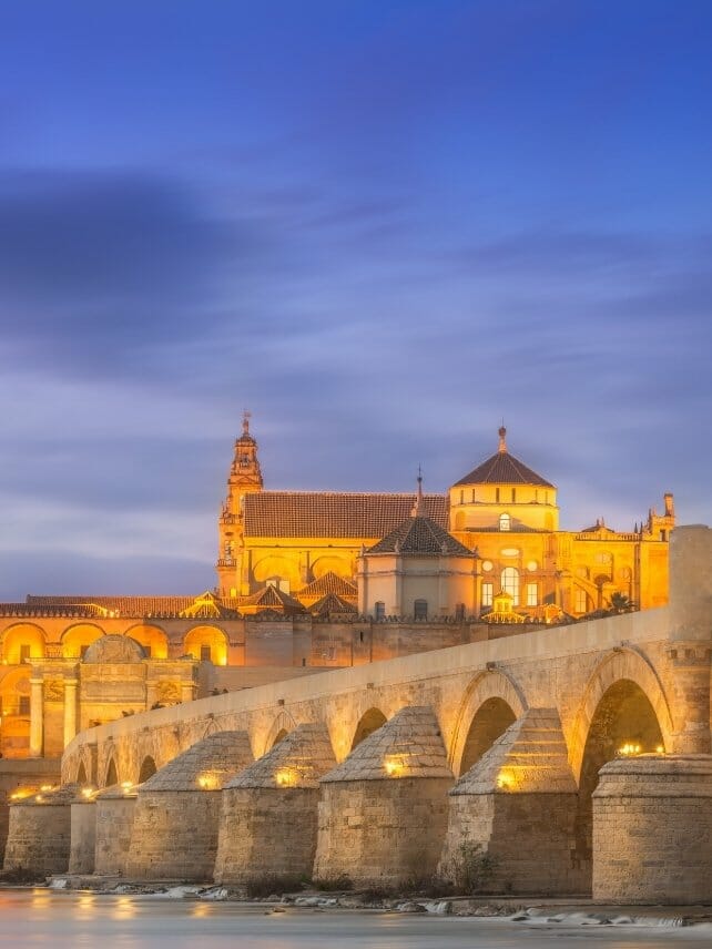 The Punta Romana and Mezquita of Cordoba lit up at twilight