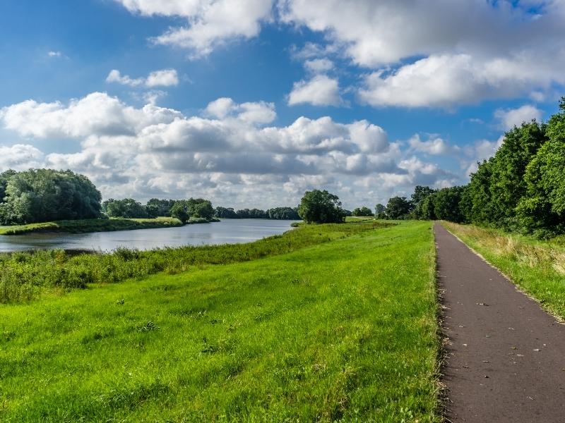 cycle path by a river through green fields