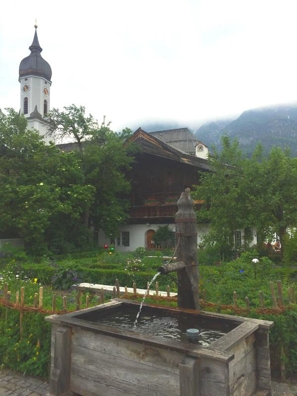 wooden watertrough with old fashioned handle and spout in front of a church in Germany