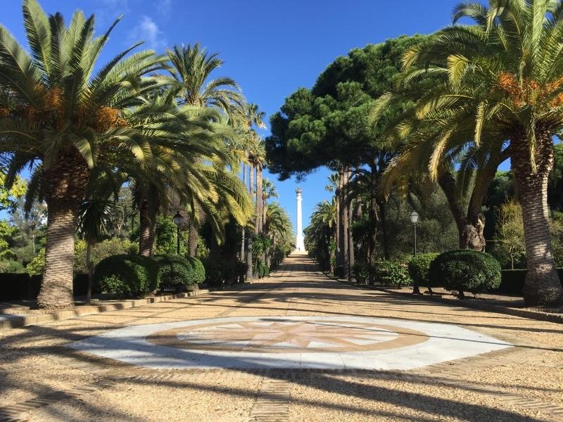 grand avenue with palm trees and statue