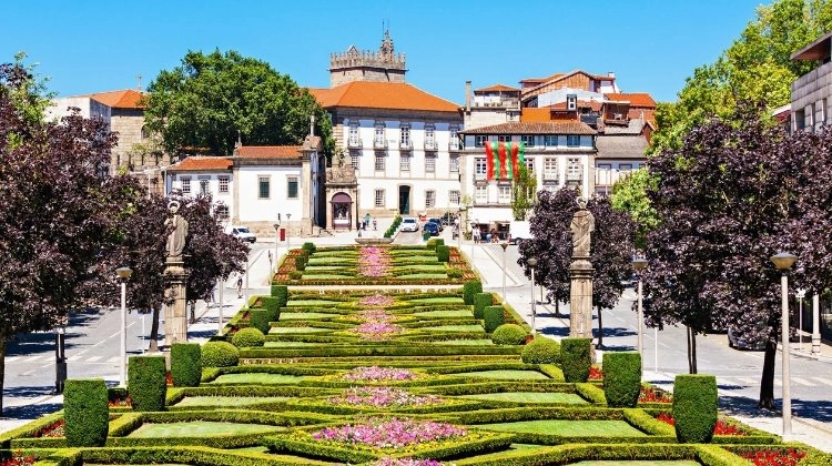 Lush green gardens of Guimaraes, with the red rooved historic town in the background