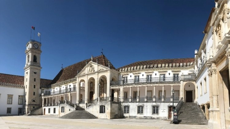 The ornate buildings of Coimbra University around a central square of pale stone