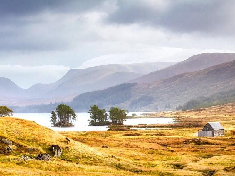 Scottish loch with a small bothy beside in in fall