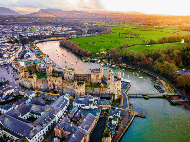 Aerial view of a medieval stone castle by a river and town
